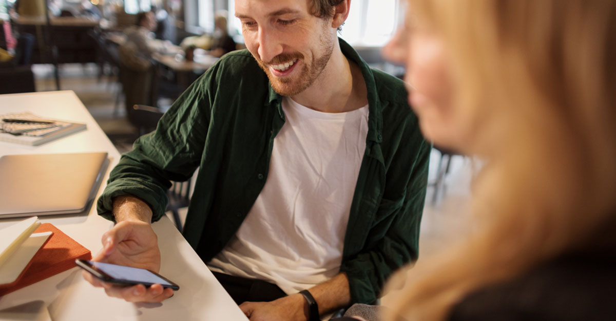 Man visar något på mobil